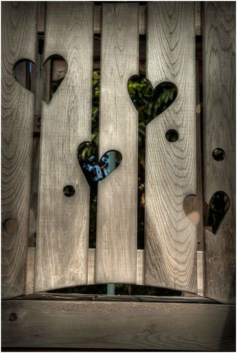 Дървена ограда с издълбани сърца.