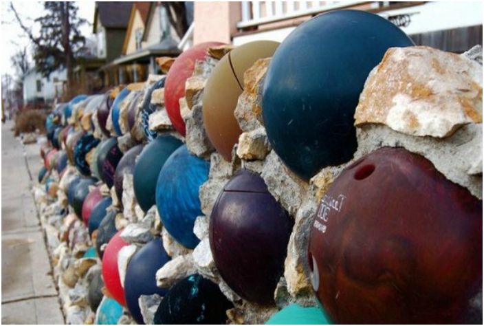 Une clôture décorée de boules de bowling.