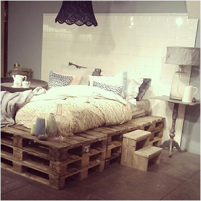 Multi-level pallet bed with an interesting white headboard, which in turn creates its own atmosphere.