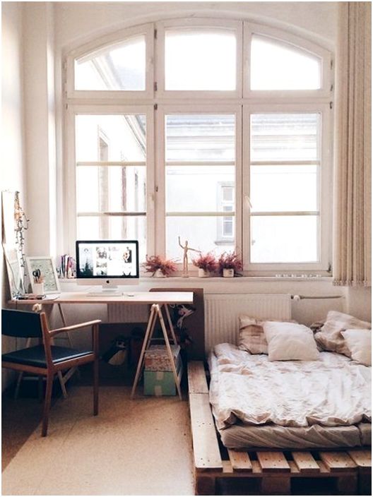 Small comfortable bedroom with a bed on pallets, something that will delight the eye.