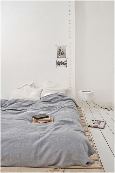 Il pallet molto basso viene utilizzato per creare il letto, che offre un comfort extra in un interno minimo della camera da letto.