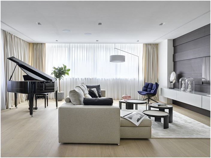 Světlý a uklizený interiér obývacího pokoje s elegantními prvky temného interiéru.