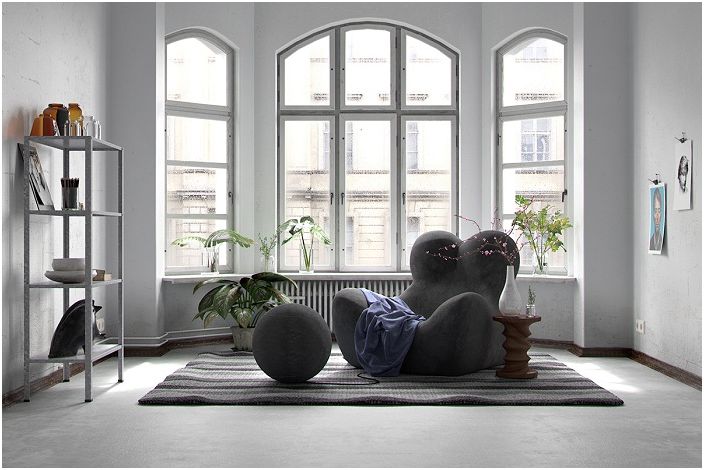 غرفة معيشة داخلية غير عادية مع كرسي بذراعين مخصص بألوان داكنة وعناصر ديكور رائعة.
