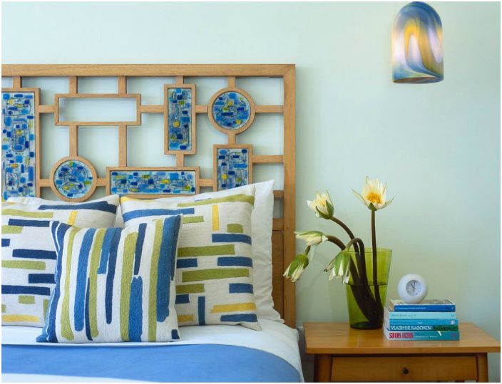 Заплетена решетка, изработена от дърво, украсена с ярки елементи, ще направи леглото стилно и оригинално.
