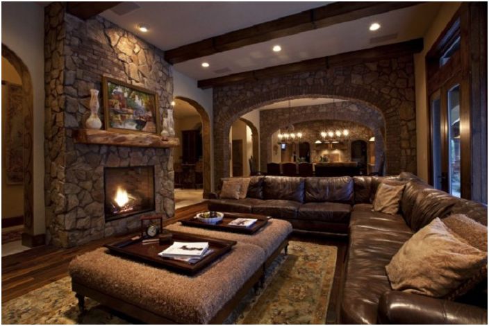 The beige and brown palette of the room is complemented by a cozy fireplace with decorative stone.