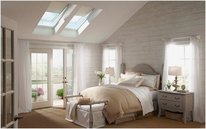 A lovely bedroom decorated in delicate cream colors for relaxation and enjoyment, with pretty dormer windows.