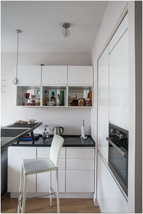 Остъклените фасади на кухненските мебели играят върху визуалното разширяване на пространството