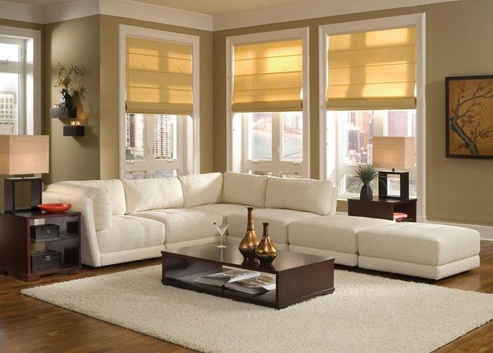 وضع أريكة تحت النوافذ في غرفة المعيشة الصغيرة يمكن أن يجعل الأثاث أكثر جاذبية وراحة.