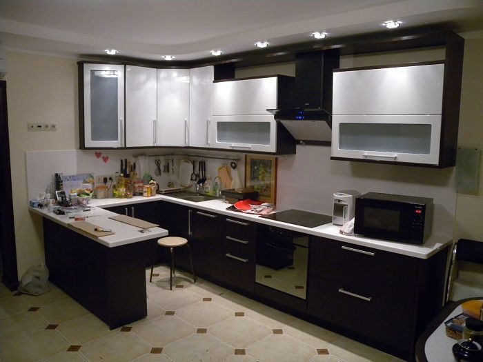 مطبخ أصلي داكن مع أسطح بيضاء تحول الداخل.