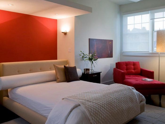 Стена окрашена в красный цвет, что преображает комнату.