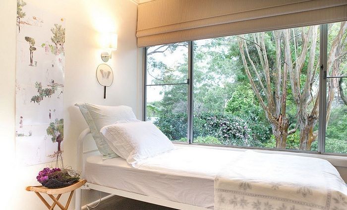 Малка светла спалня прави лека къдрава към ориенталския стил в интериора.