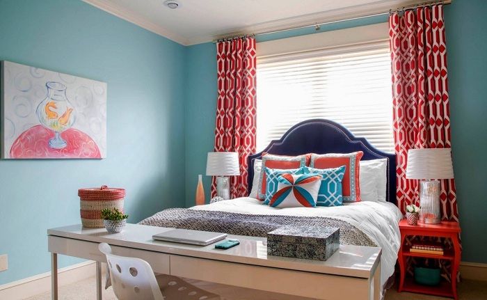 Zanimljiv dizajn spavaće sobe s plavim zidovima i originalnim grimiznim zavjesama.