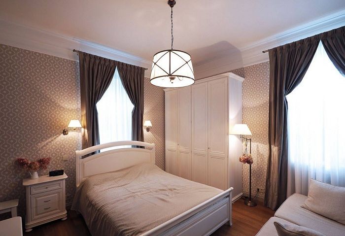 غرفة نوم بألوان ناعمة مع ستائر شوكولاتة داكنة أصلية.
