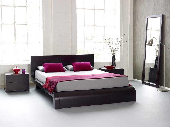 Спалнята е трансформирана чрез поставяне на оригиналното легло върху платформа плюс ярки пурпурни елементи.
