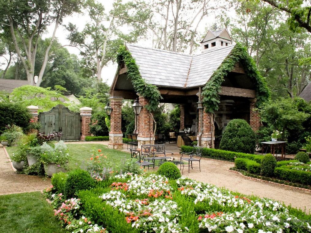 Combinação orgânica de elementos de composição - um mirante, uma cerca, becos, canteiros de flores, arbustos e plantas ampélicas